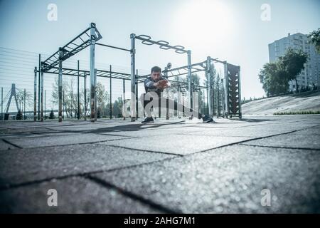 Confident sportsman doing morning exercises while being at the sports ground Stock Photo