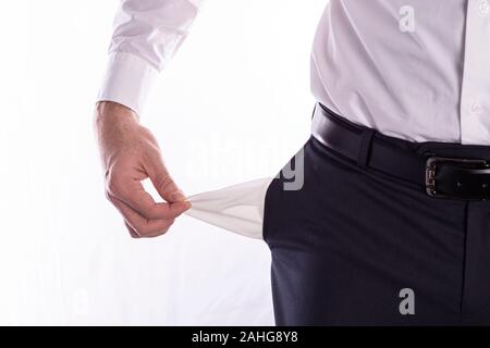 Businessman with empty pockets, man's hands are holding empty pockets of trousers on a white background with space for text Stock Photo
