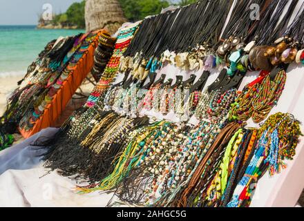 Souvenirs, necklaces, wristbands, bracelets and different accessories display stand on the beach in the island of Koh Pha Ngan, Thailand Stock Photo