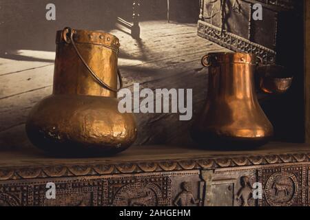 Couple of medieval copper pots on wood furniture. Old ancient furniture pieces Stock Photo