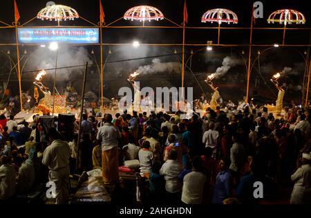 Pandits, or Hindu priests, perform a devotional ritual using fire as an offering to the Goddess Ganga. Ganga Aarti, Ganges River, Varanasi, India. Stock Photo