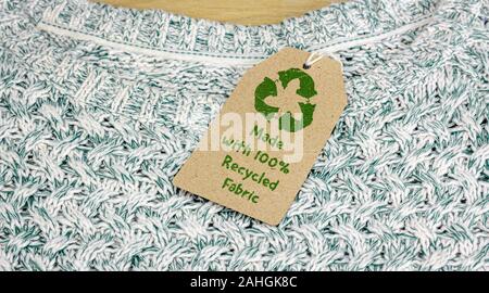 Recycle clothes icon on fabric label with 100% Recycled text, concept ...