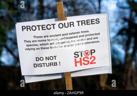 Denham, UK. 29th December 2019. Stand for the Trees, a Walk for Wildlife and Water, organised by Chris Packham and supported by Extinction Rebellion, #ReThinkHS2, Save the Colne Valley, STOP HS2 and Hillingdon Green Party. Speakers described the threats to the habitats that are the homes of endangered eels, bats, otters, water voles, the loss of 28,000 trees to HS2 and the chalk aquifer that contributes to much of London’s water. Pictured, Protect Our Trees, Stop HS2 placard. Credit: Stephen Bell/Alamy Stock Photo