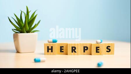 Herpes - word from wooden blocks with letters, viral diseases herpes viruses concept, blue background Stock Photo