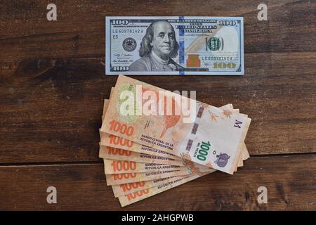 100 dollar bill with Argentine peso bills, symbolic for money exchange rate Stock Photo