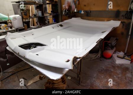 Finishing the gray ceiling from a car removed and disassembled for repair and hauling with new material after prolonged use or during tuning. Auto ser Stock Photo