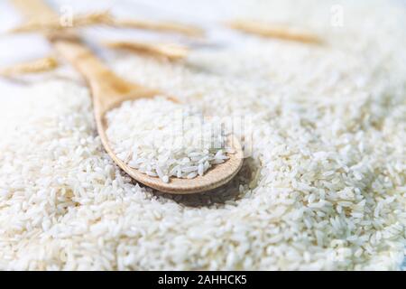 uncooked rice in wooden spoon closeup Stock Photo