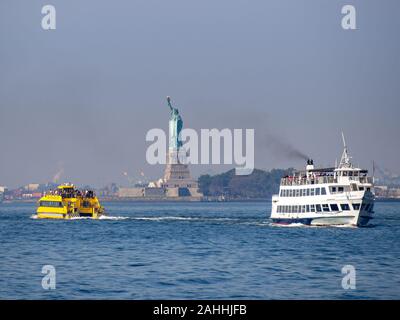 Liberty island, New York City - Statue of Liberty on Hudson river during cruise sunset at dusk Stock Photo