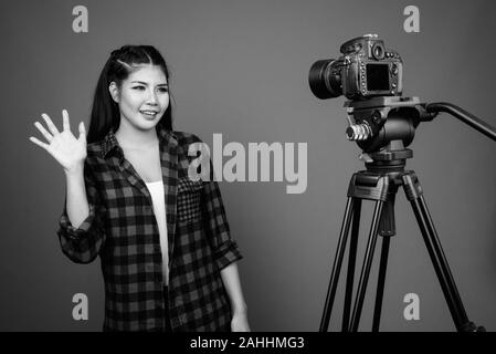 Young beautiful Asian hipster woman against gray background Stock Photo