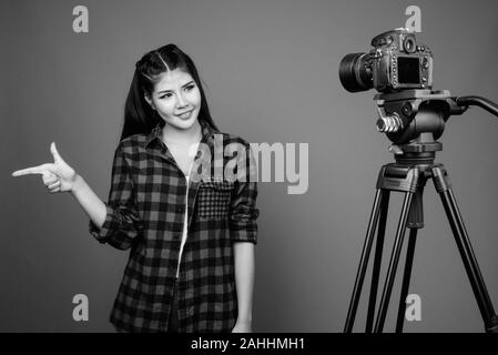 Young beautiful Asian hipster woman against gray background Stock Photo