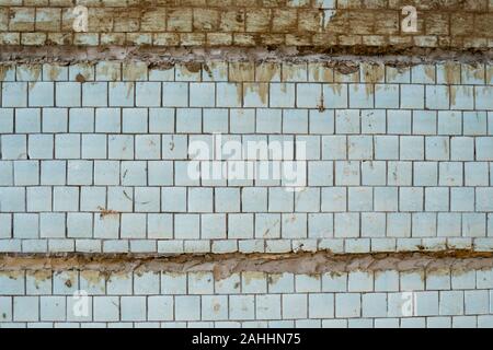 Blue tiles on a wall as a background image. Blue old tile with seams between concrete slabs. Stock Photo