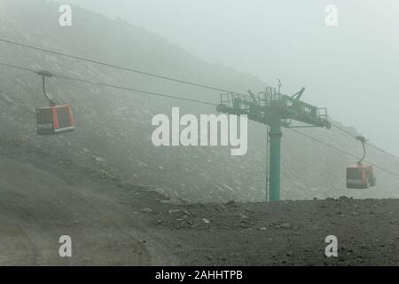 Landscape of Etna with cable car in the fog, Sicily, Italy Stock Photo