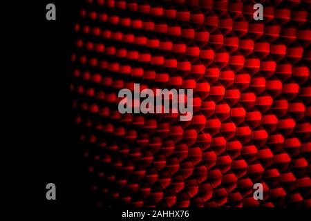 Closeup honeycomb grid texture with red light. Red and dark metal hexagon shaped pattern abstract background. Light modifier equipment. Metal honey Stock Photo
