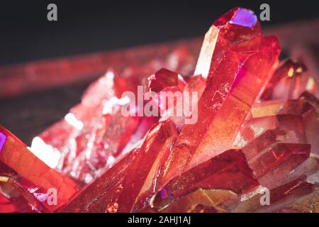 Red Aura Quartz with light shine on, to show how glitter it is on black background Stock Photo