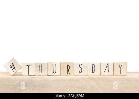 Wooden cubes with hashtag and the word Thursday, social media concept near white background Stock Photo