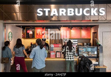 Customers ordering coffee at the American multinational chain, Starbucks Coffee shop in Hong Kong international airport. Stock Photo