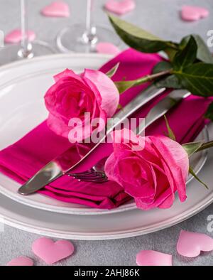 Closeup of two pink roses on a table setting for Valentines Day Stock Photo