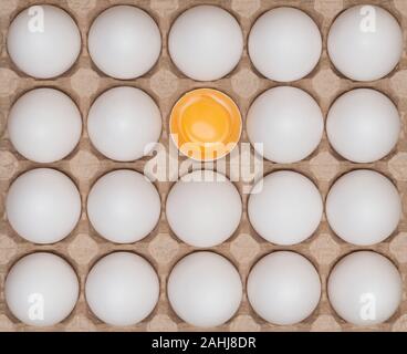 White chicken eggs in the carton box on the wooden table. Stock Photo