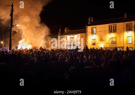 Crowds at bonfire celebrate New Year at Allendale New Year's Eve Tar Bar'l ceremony where burning Tar Barrels are carried and thrown on to the fire. Stock Photo