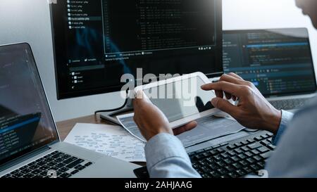 Programmer working On Computer In IT Office Typing Data Coding in software and checking code on computer screen Stock Photo