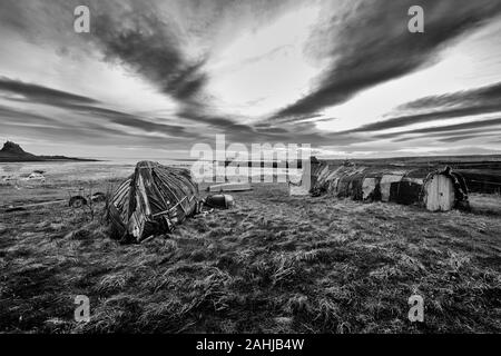 Upturned herring boats on the Island of  Lindisfarne (Holy Island on the Northumberland coast. England, UK, GB. Stock Photo