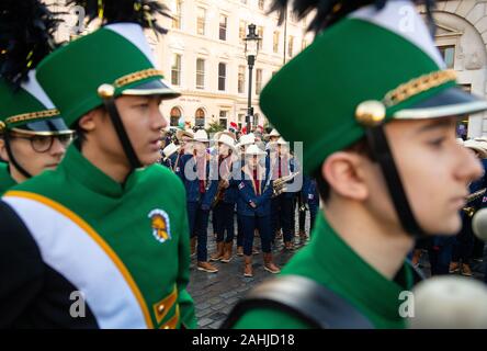 Members of the Glenbrook North High School Spartan Marching Band, from Illinois, USA, (foreground) and performers from the Carnaval del Pueblo during a preview of London New Year's Day Parade at the Covent Garden Piazza in London. Stock Photo