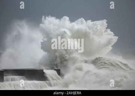 Stormy waves splash and wind spray against ocean pier from northern Portugal. Stock Photo