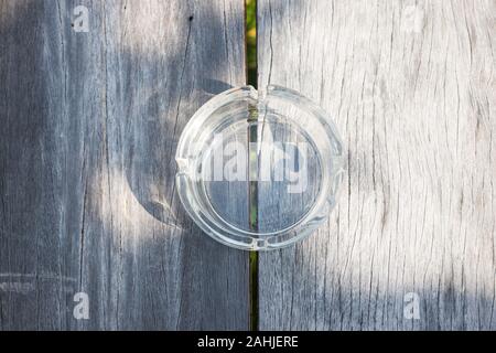 glass ashtray transparent put on center of wooden table look from the top Stock Photo