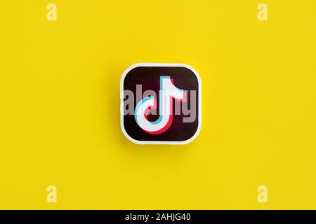 NY, USA - DECEMBER 5, 2019: Tiktok paper logo on yellow background. TikTok is a popular video-sharing social networking service owned by ByteDance Stock Photo