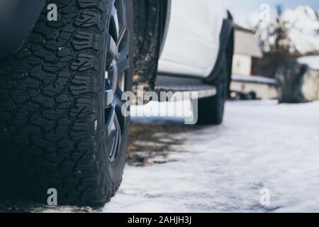 Close-up of car all-terrain winter tires on the snow covered road Stock Photo