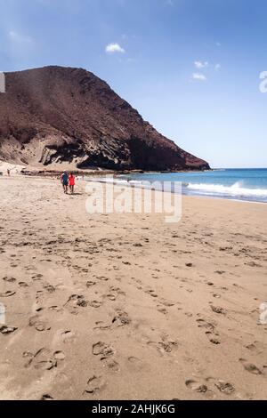 Unrecognizable people swimming, sunbathing and walking on La Tejita beach in Granadilla de Abona municipality, El Medano, Tenerife, Canary Islands Stock Photo