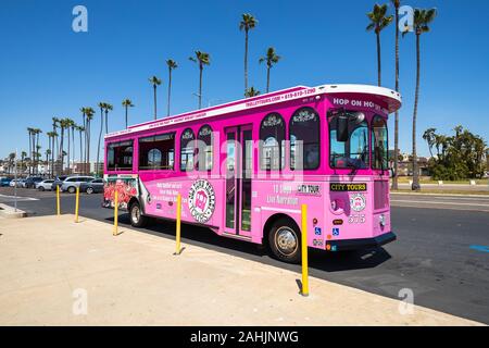 A pink trolley from Old Town Trolley Tours stops along Harbor Drive in San Diego, California, USA Stock Photo