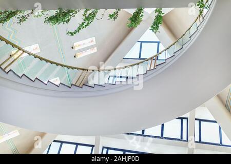 Hurghada, Egypt - July 5, 2019: Fragment of interior in lobby of Pharaoh Azur Resort Hotel. Pyramid shaped roof with windows, staircase and greenery. Stock Photo