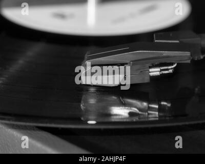 Black and white photo of vintage dj turntables needle cartridge in focus.Overhead shot of dj turntable tone arm.Professional vintage dj audio equipmen Stock Photo