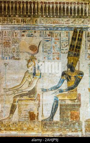 UNESCO World Heritage, Thebes in Egypt, ptolemaic temple of Deir el Medineh. Hathor and Amun-Ra seated on thrones. Stock Photo