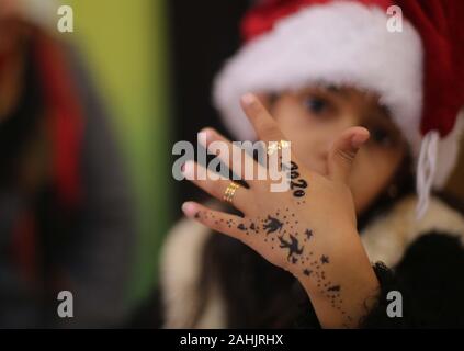 Gaza City, The Gaza Strip, Palestine. 30th Dec, 2019. A Palestinian girl welcoming the new year by drawing a Henna Tattoo with the new year numbers 2020 on her hand at Gaza city Credit: Majd Abed/Quds Net News/ZUMA Wire/Alamy Live News Stock Photo