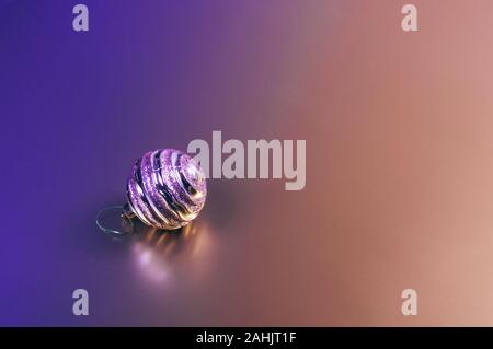 A shiny Christmas decorative ball on two colored background. Place for text. Stock Photo