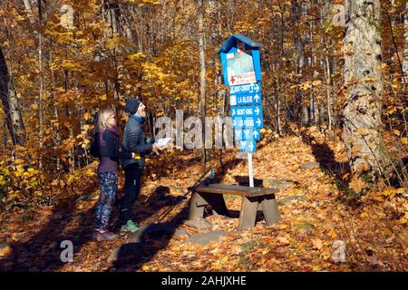 Two hikers consulting a trail map at Parc Régional de Val David, province of Quebec, Canada. Stock Photo