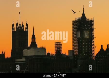 Westminster, London, 30th Dec 2019. The Houses of Parliament silhouetted at sunset, with the Elizabeth Tower still in scaffolding. A beautifully sunny winter day in London concludes with a soft pastel sunset in Westminster. Credit: Imageplotter/Alamy Live News Stock Photo