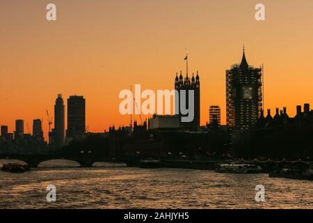 Westminster, London, 30th Dec 2019. The Houses of Parliament silhouetted at sunset, with the Elizabeth Tower still in scaffolding. A beautifully sunny winter day in London concludes with a soft pastel sunset in Westminster. Credit: Imageplotter/Alamy Live News Stock Photo