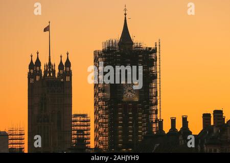 Westminster, London, 30th Dec 2019. The Houses of Parliament silhouetted at sunset, with the Elizabeth Tower still in scaffolding. A beautifully sunny winter day in London concludes with a soft pastel sunset in Westminster. Credit: Imageplotter/Alamy Live News Stock Photo