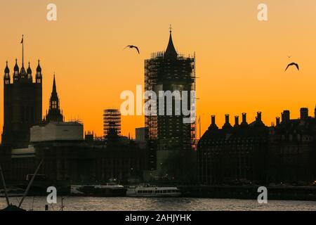Westminster, London, 30th Dec 2019. The Houses of Parliament silhouetted at sunset, with the Elizabeth Tower still in scaffolding. A beautifully sunny winter day in London concludes with a soft pastel sunset in Westminster. Credit: Imageplotter/Alamy Live News Stock Photo