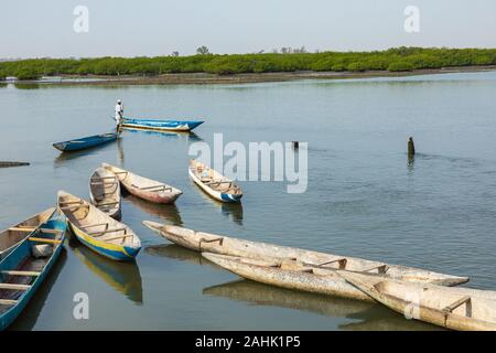 JOAL-FADIOUTH, SENEGAL - NOVEMBER15, 2019: Fishers and small long boats. Fadiauth Island. Senegal. West Africa. Stock Photo