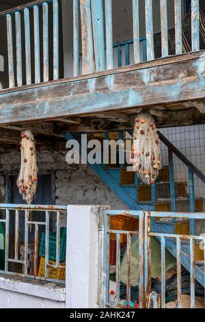 Wooden balconies and fishing nets in the village of Psarades on Lake Prespa in Macedonia, Northern Greece. Stock Photo