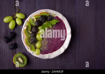 Overhead view of a smoothie bowl made from acai powder, grapes, blackberries, and chia seed Stock Photo