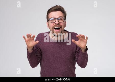 Excited bearded man in glasses is excited to see gift for his birthday. Stock Photo