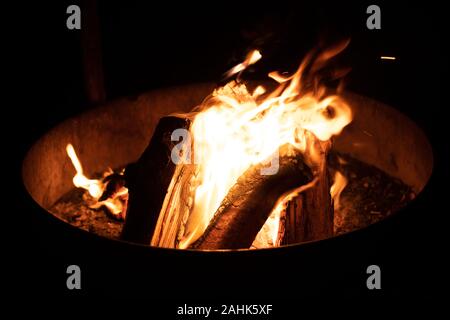 A glowing camp fire providing comfort and light during a cool summer night in a national park. Stock Photo