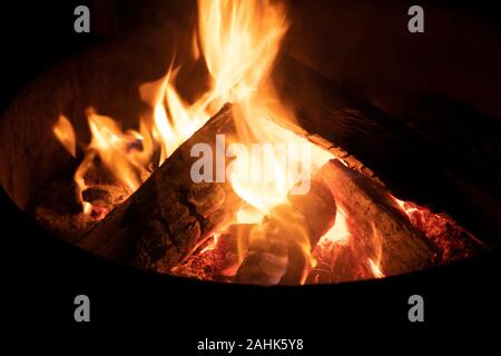 A glowing camp fire providing comfort and light during a cool summer night in a national park. Stock Photo