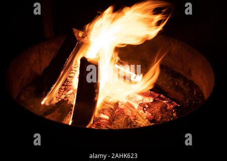 A glowing camp fire providing comfort and light during a cool summer night in a national park. Stock Photo