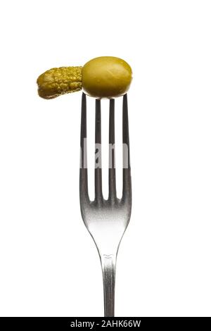One olive a small cucumber on a fork a white background Stock Photo
